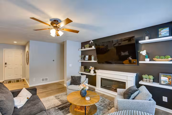Living room with built-in shelving, fireplace, and accent wall